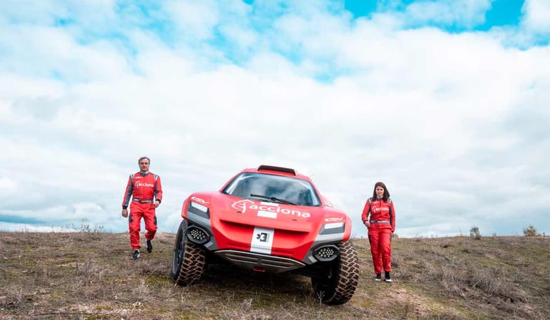 Racing red car with Acciona logo and two pilots